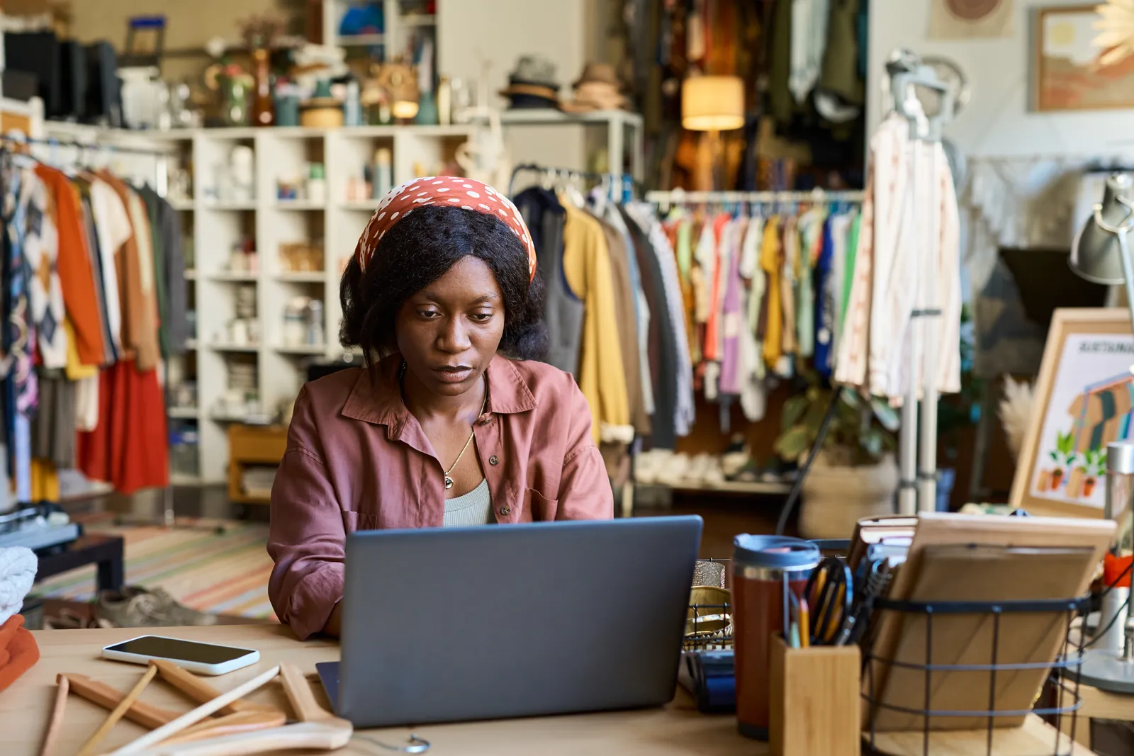 Small business owner checking her shop's accounts on a laptop