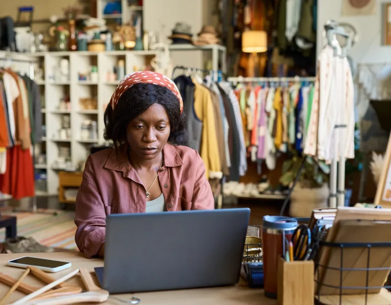 Small business owner checking her shop's accounts on a laptop